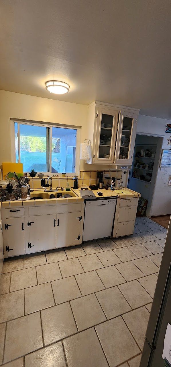 A kitchen with a stove , sink , and dishwasher.
