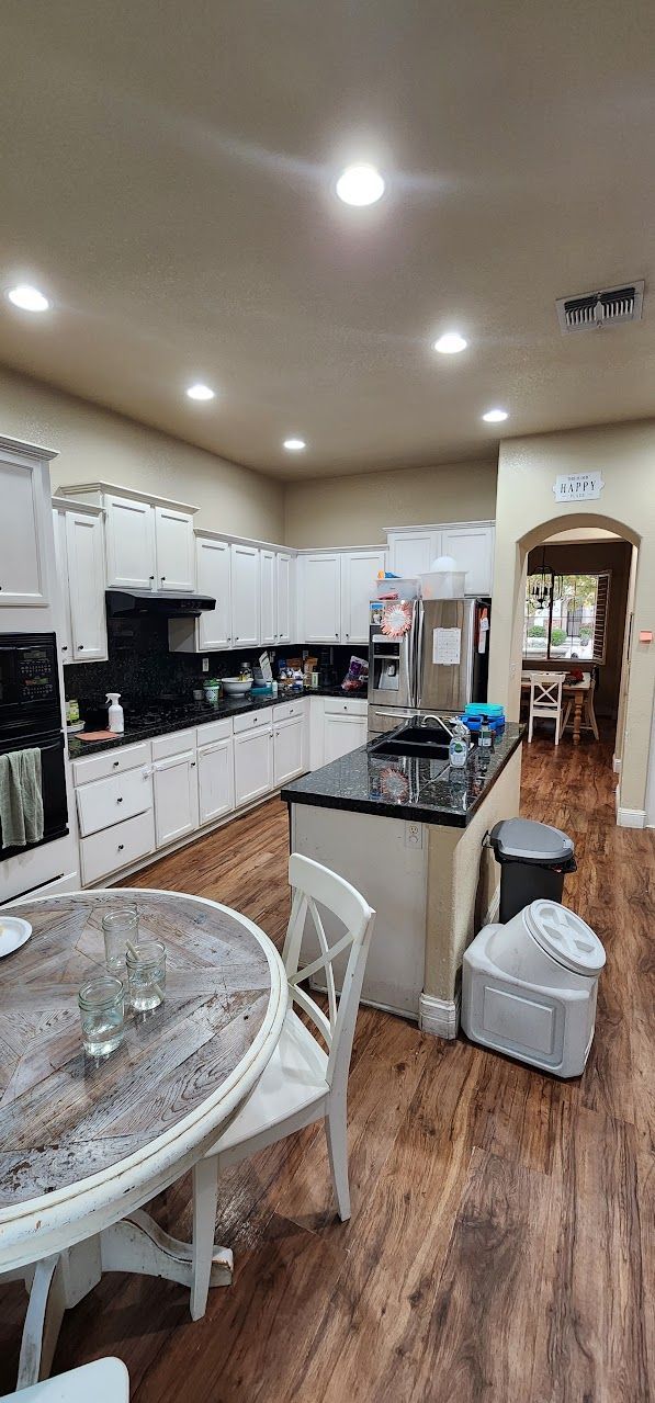 A kitchen with a table and chairs in it.