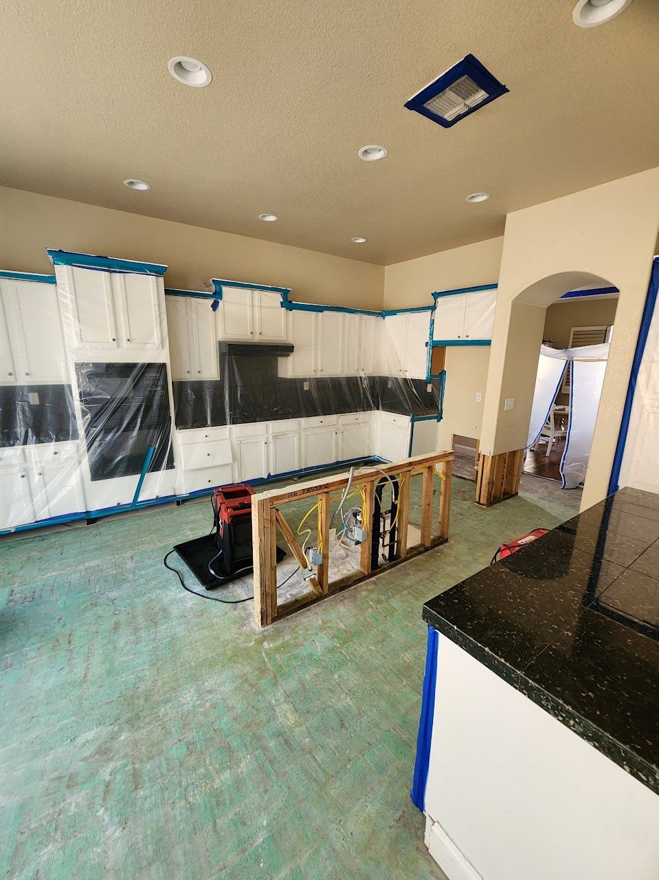 A kitchen is being remodeled and covered in plastic.