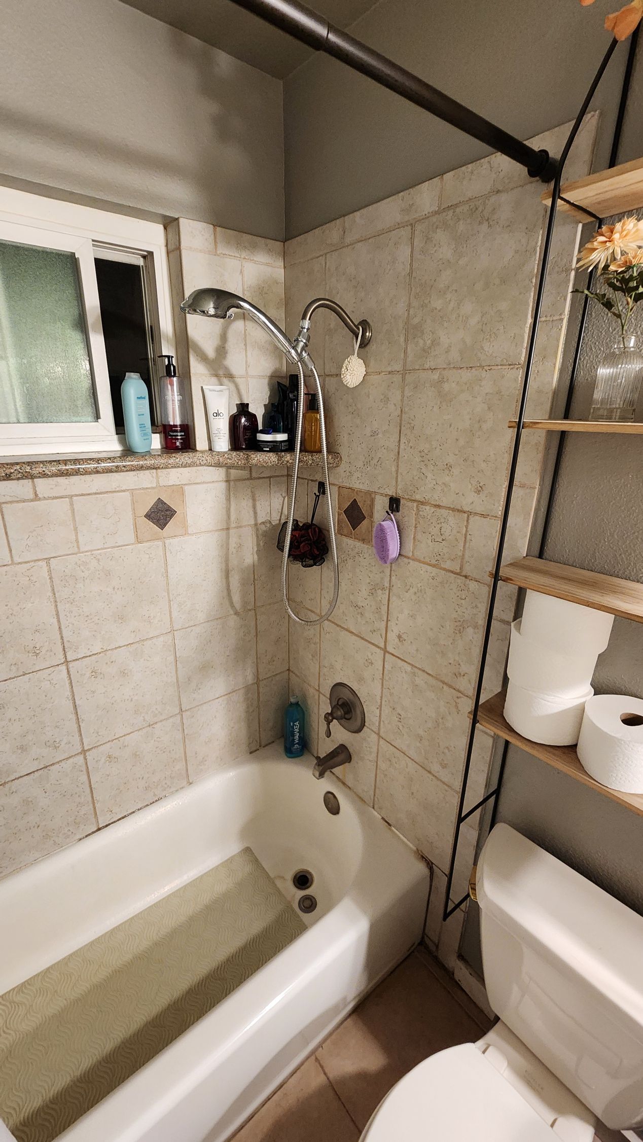 A bathroom with a bathtub , toilet and shower.