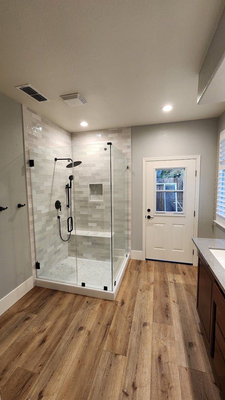 A bathroom with a walk in shower and a sink.