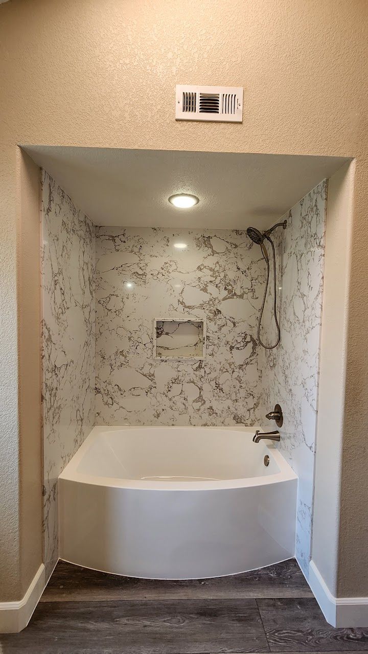 A bathroom with a bathtub and a shower.