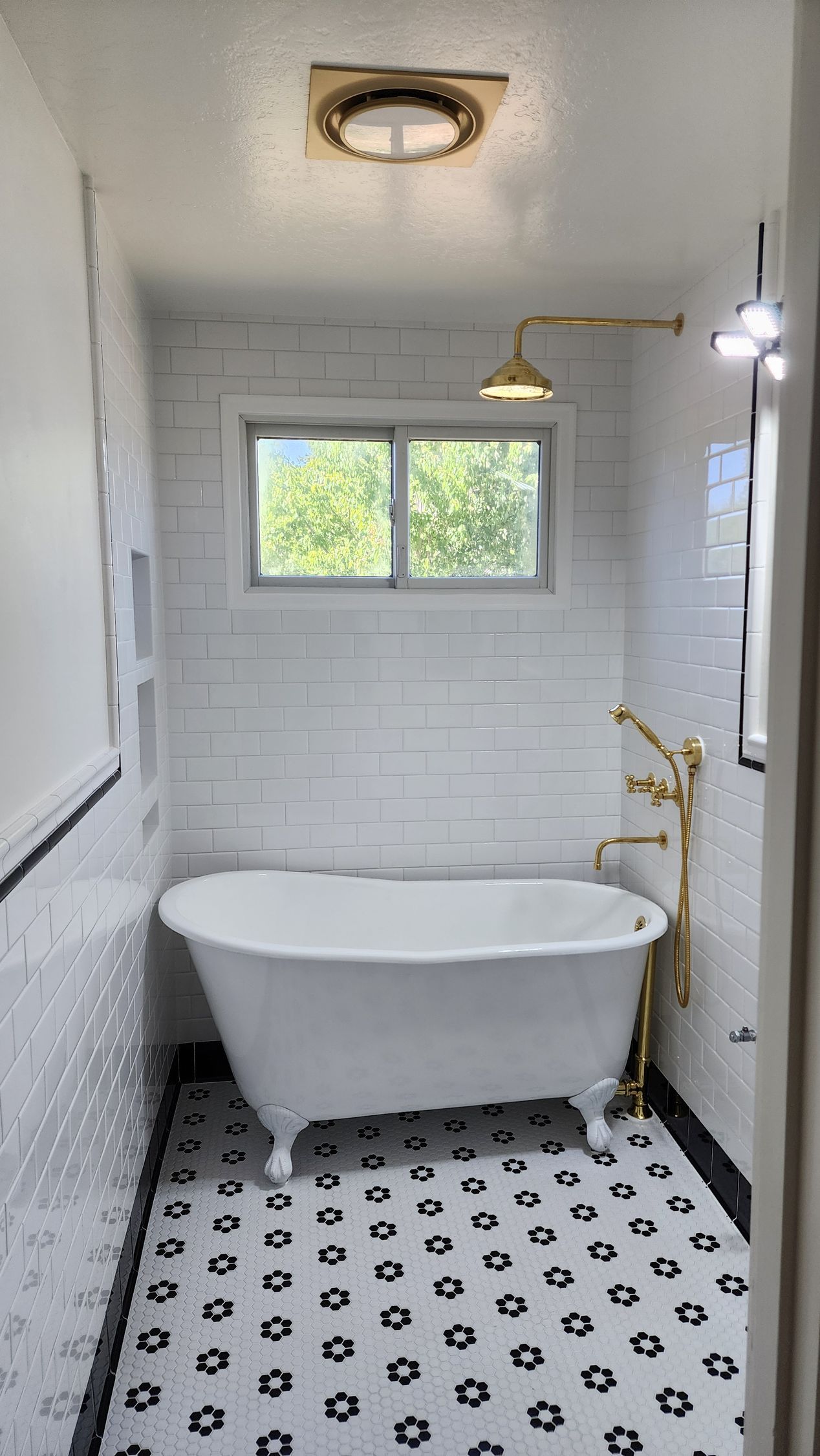 A bathroom with a bathtub and a window.