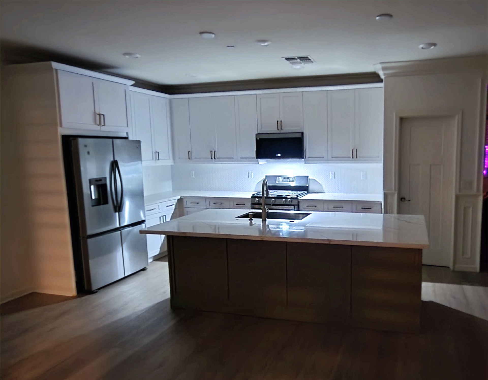 A kitchen with white cabinets and stainless steel appliances