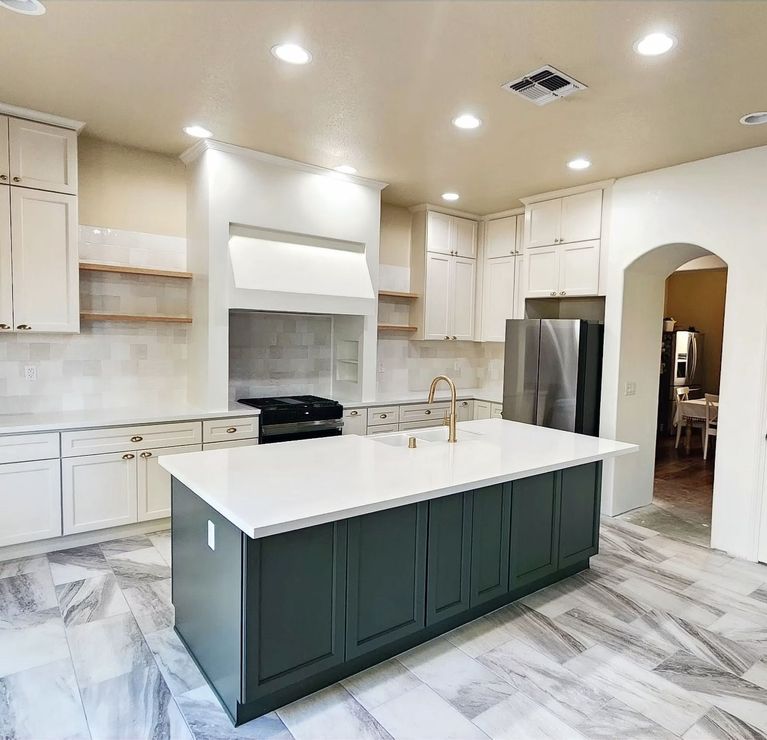A kitchen with a large island and white cabinets