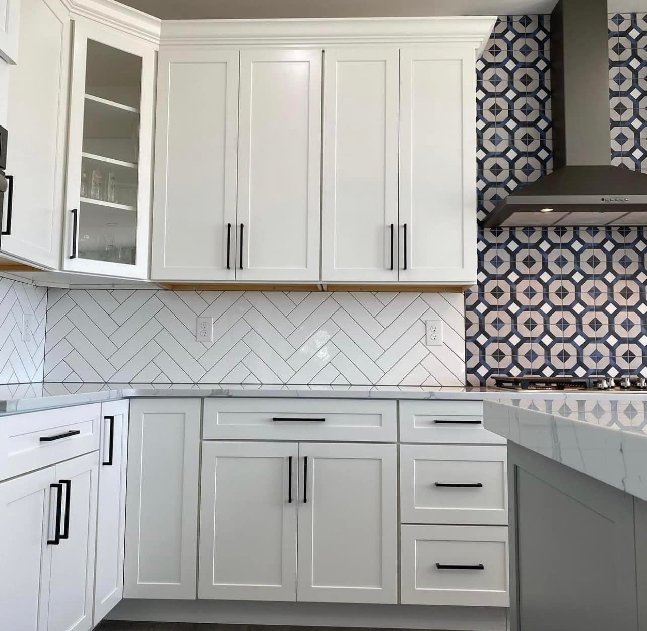 A kitchen with white cabinets and a stove top oven