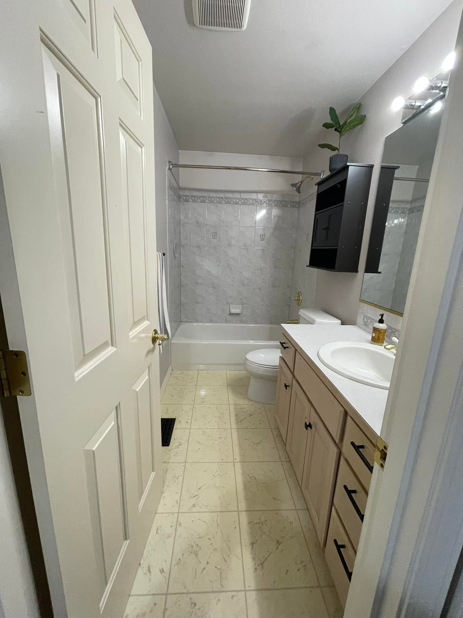 A bathroom with a sink , toilet , bathtub and mirror.