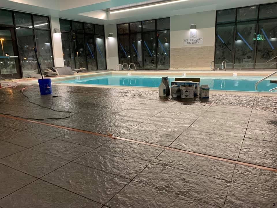 A large indoor swimming pool with buckets on the floor.