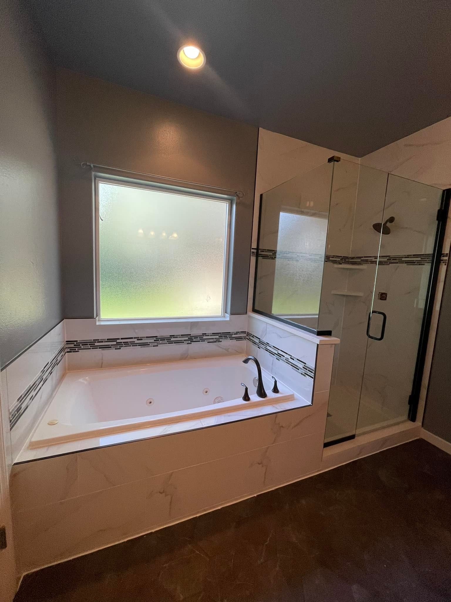 A bathroom with a jacuzzi tub and a walk in shower.