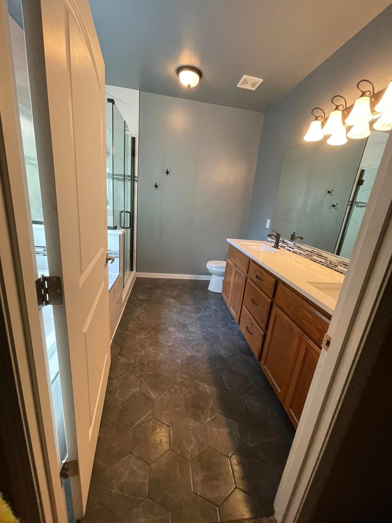 A bathroom with two sinks , a toilet , and a mirror.