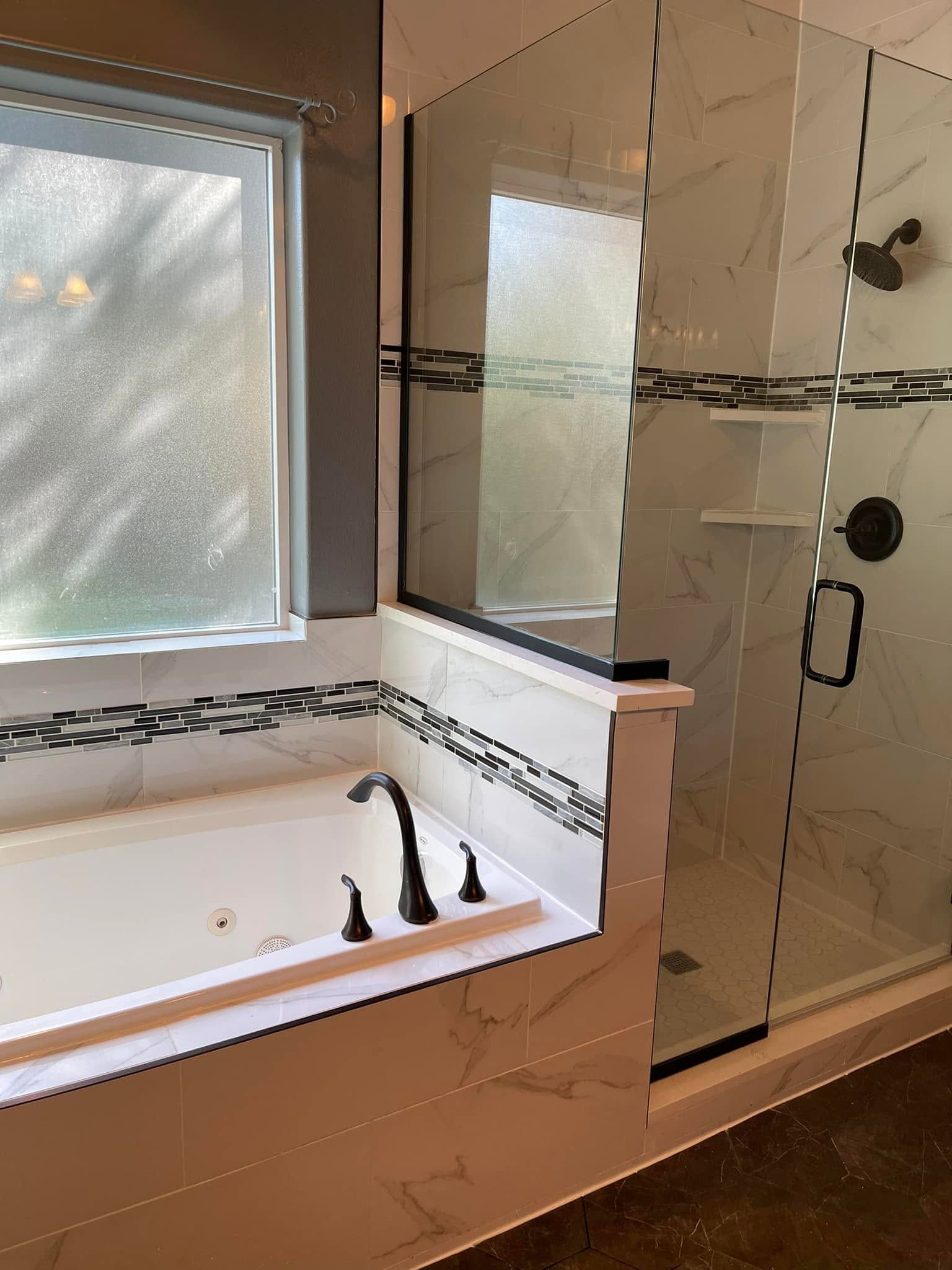 A bathroom with a jacuzzi tub and a walk in shower.