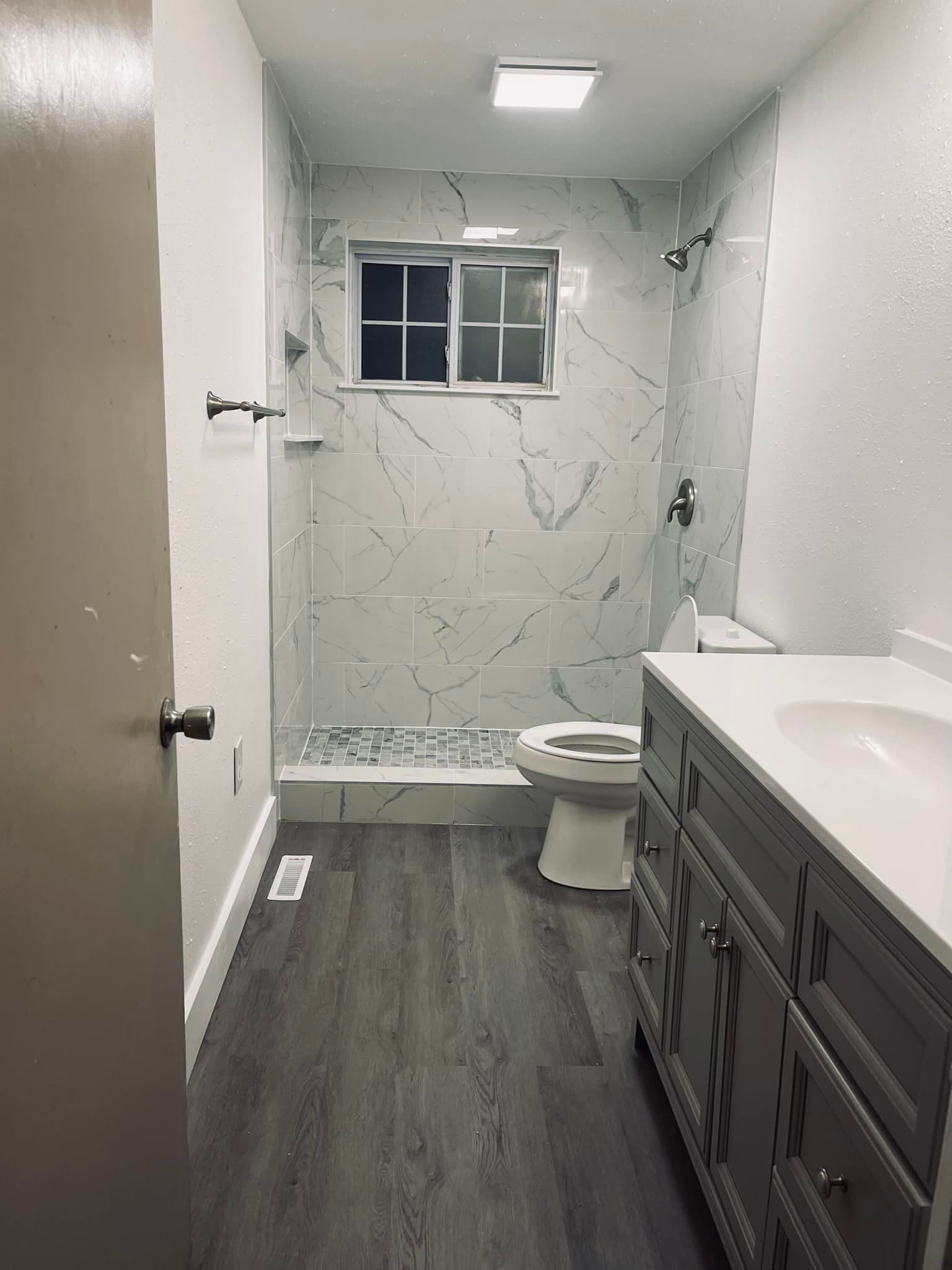 A bathroom with a toilet , sink , and shower.