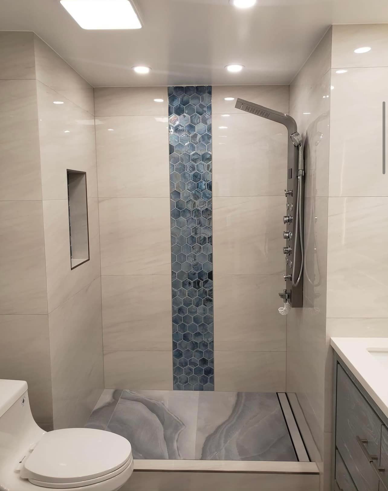 A bathroom with a toilet a sink and a shower