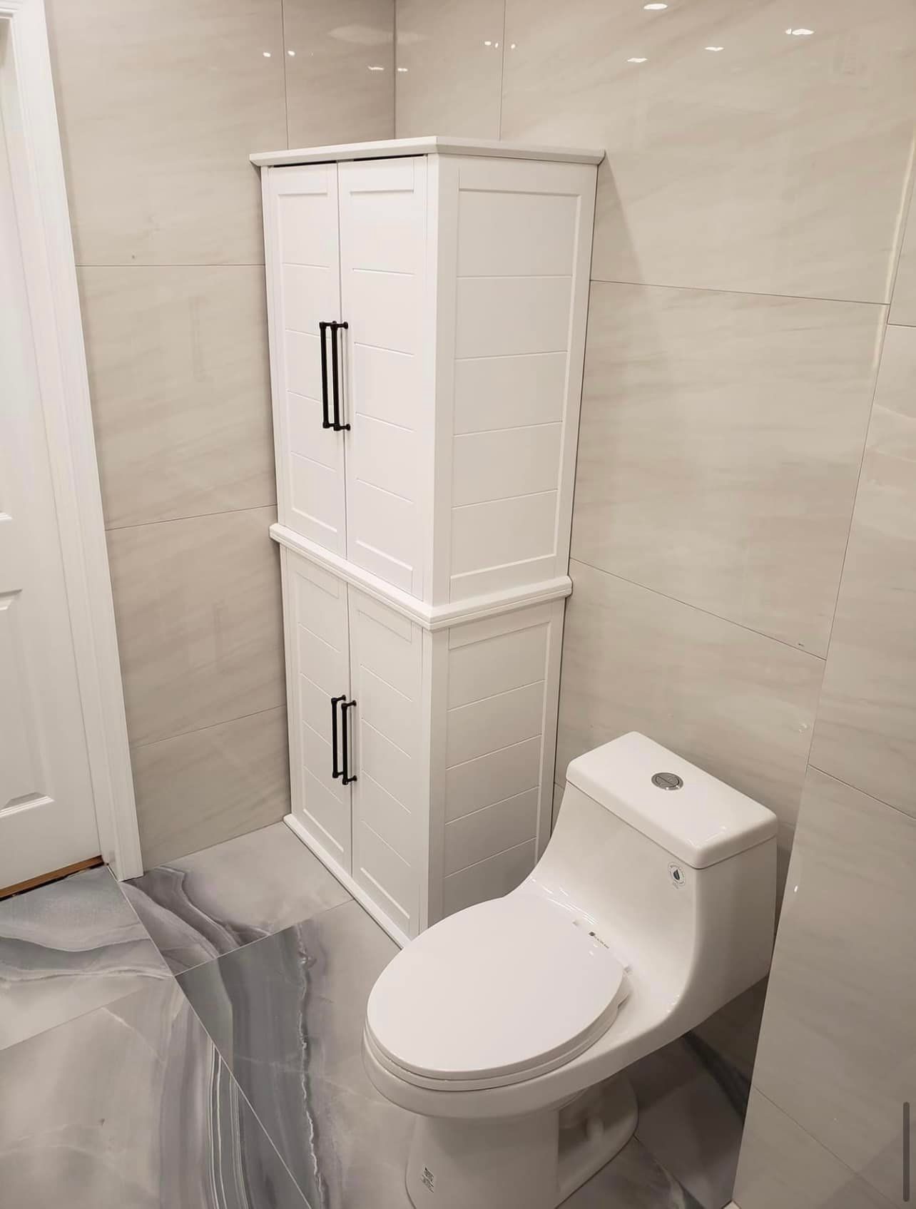 A bathroom with a toilet and a cabinet.