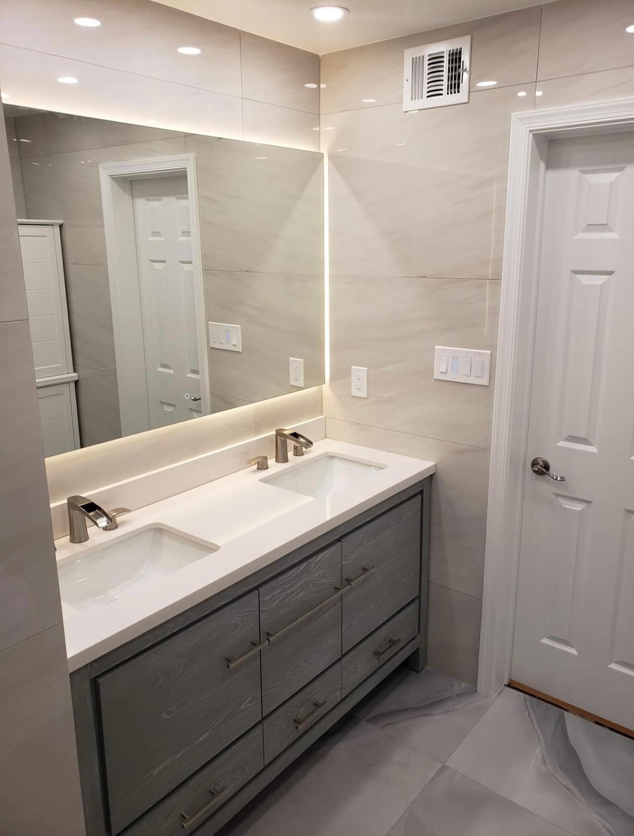 A bathroom with two sinks and a large mirror.