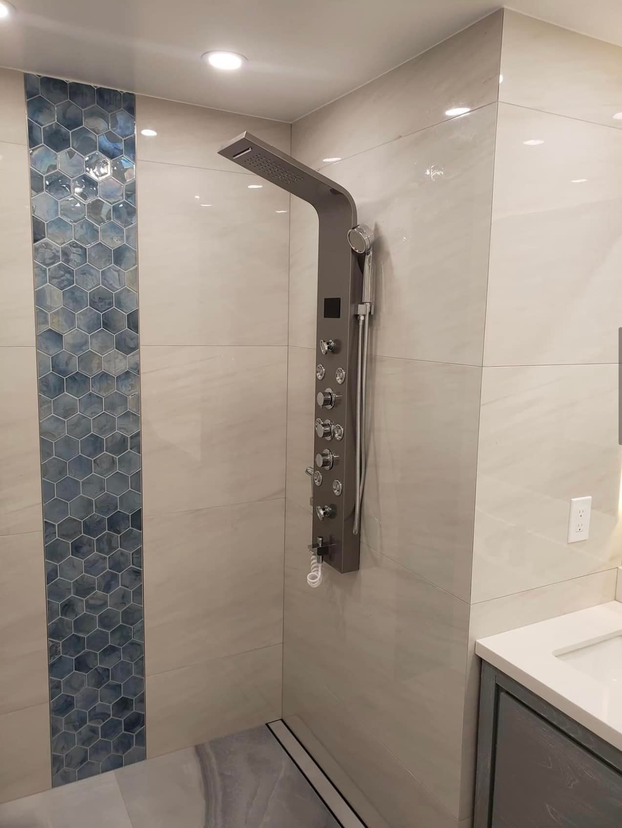 A bathroom with a shower head and a sink.