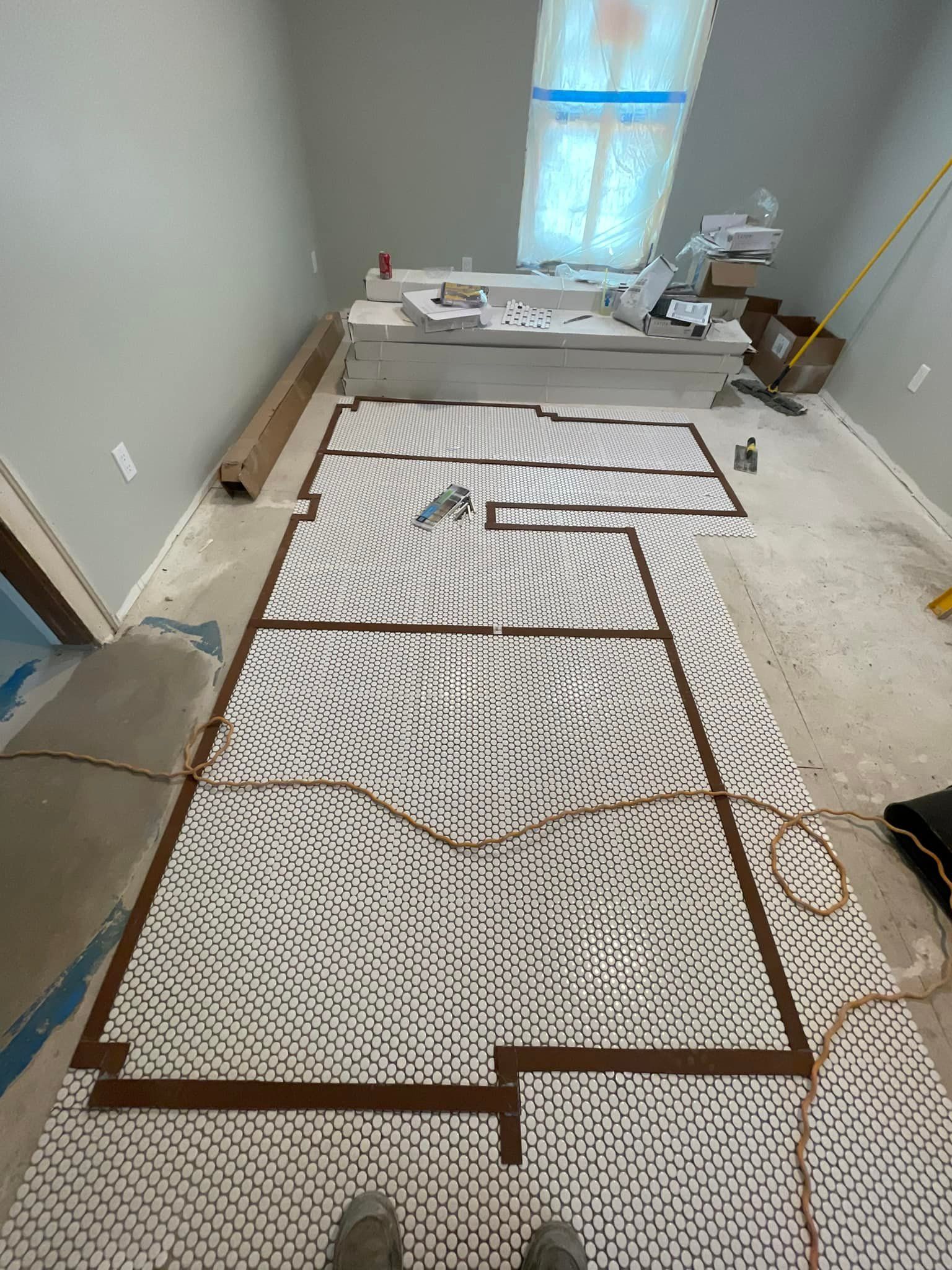 A person is standing on a tile floor in a room.
