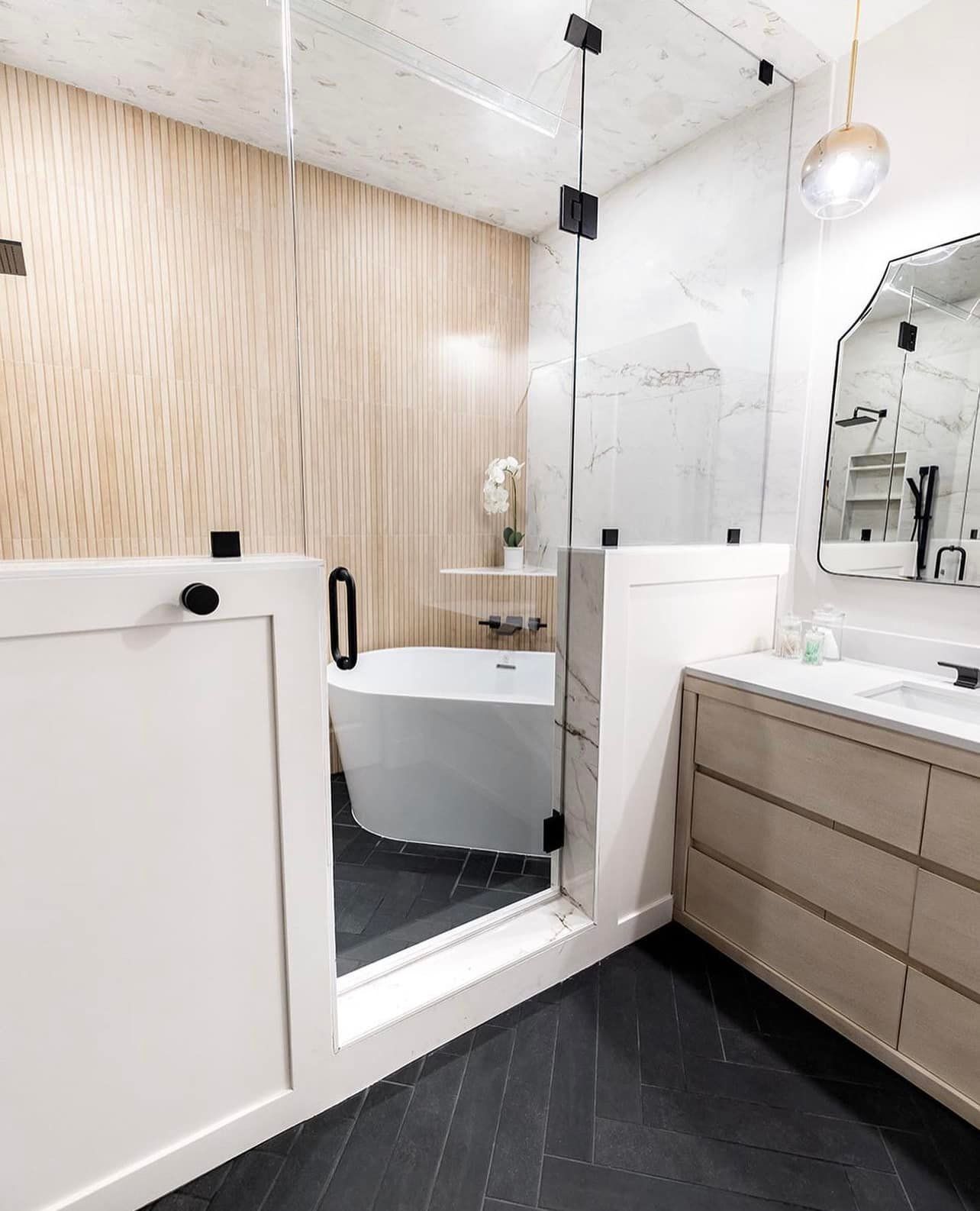 A bathroom with a tub , sink , mirror and walk in shower.