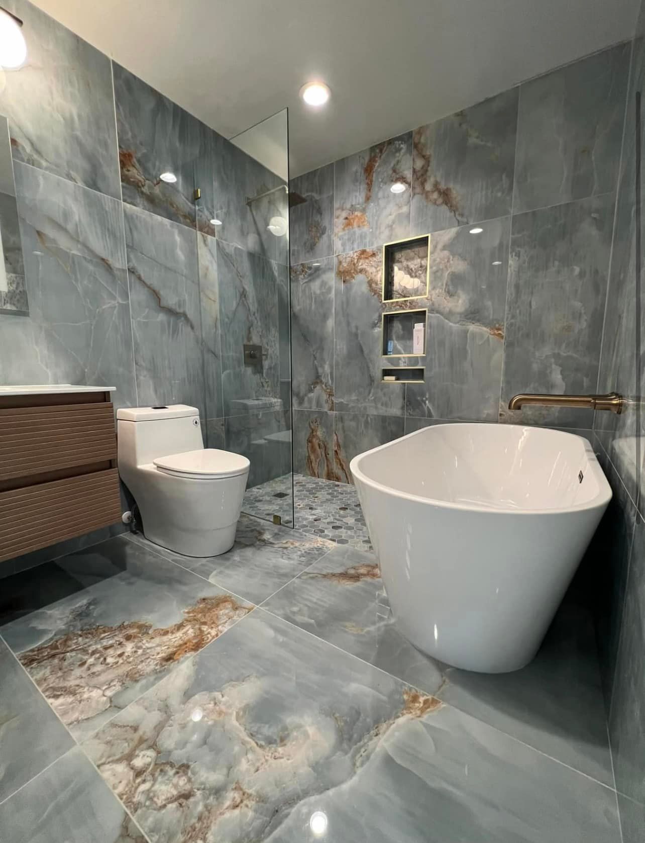 A bathroom with a tub , toilet , sink and shower.