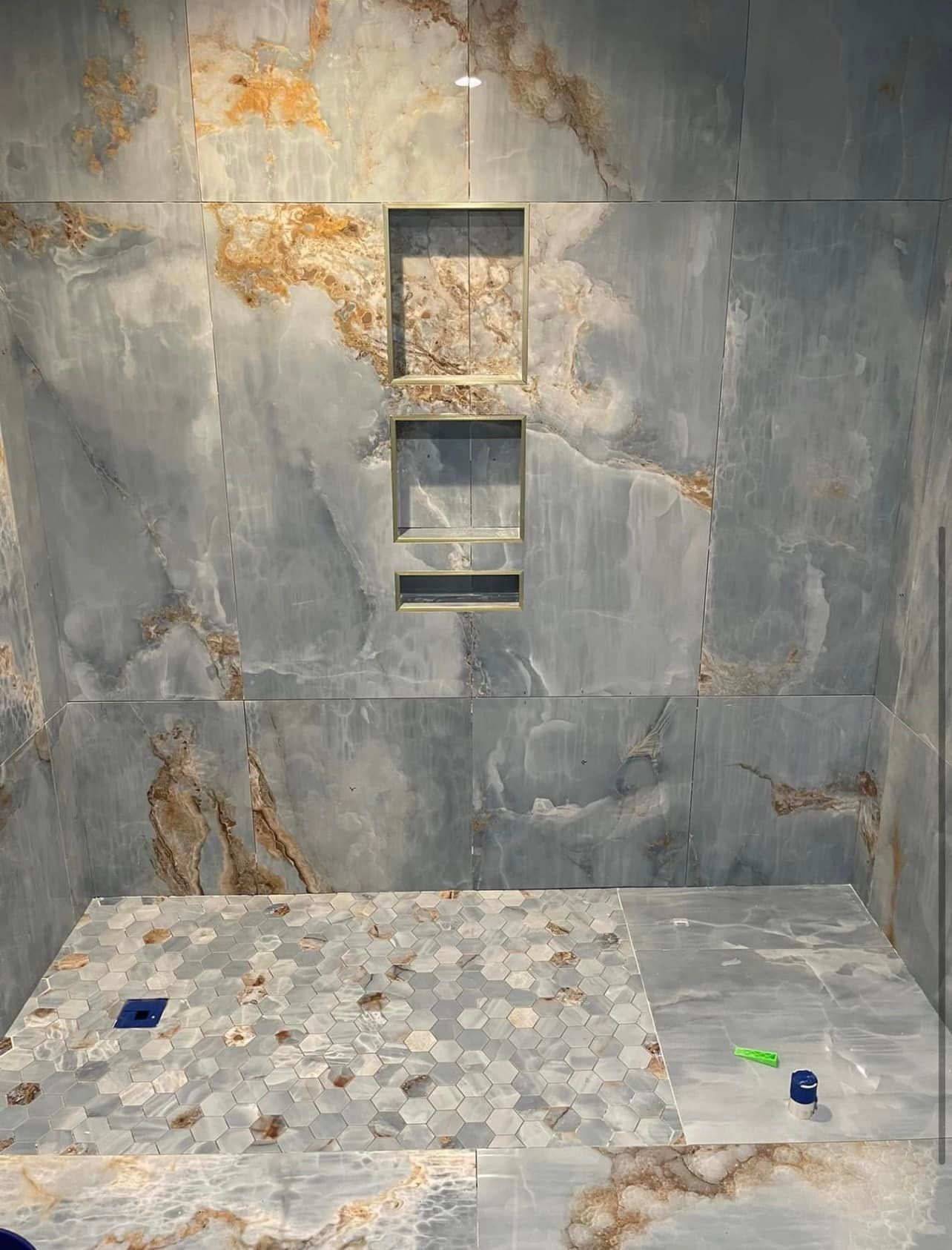 A bathroom with marble tiles and a walk in shower.
