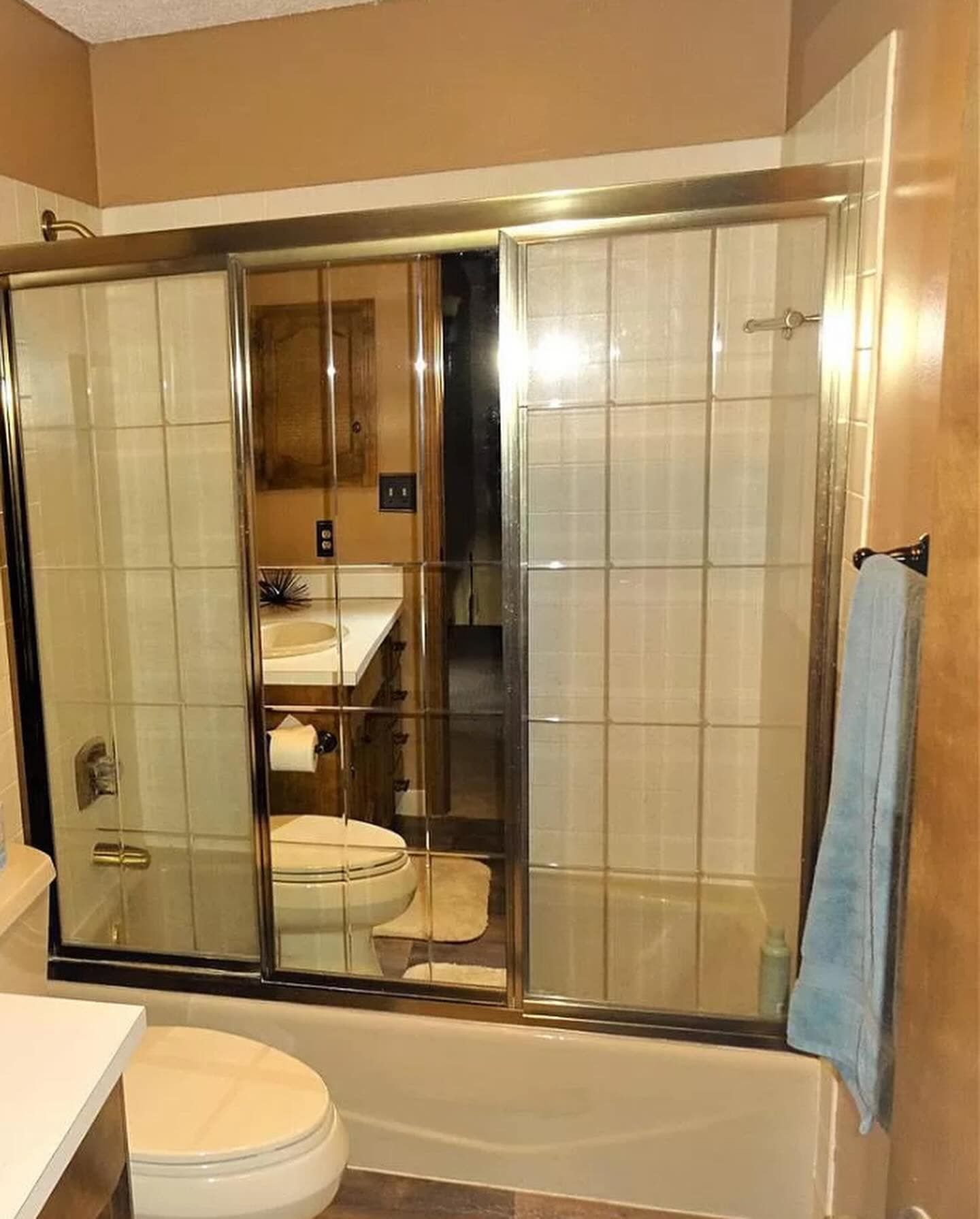 A bathroom with a sliding glass shower door