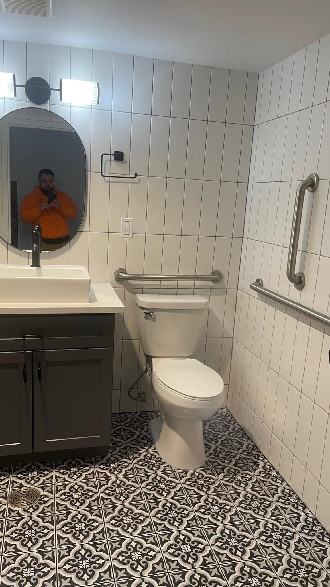 A bathroom with a toilet , sink and mirror.