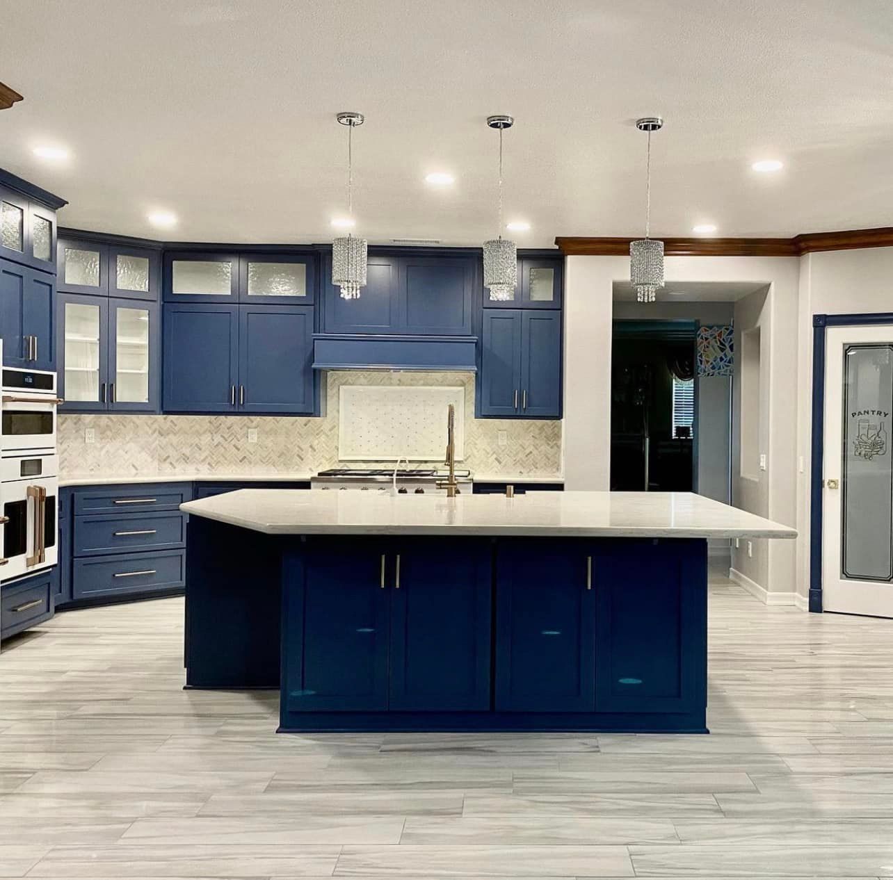 A kitchen with blue cabinets and white counter tops