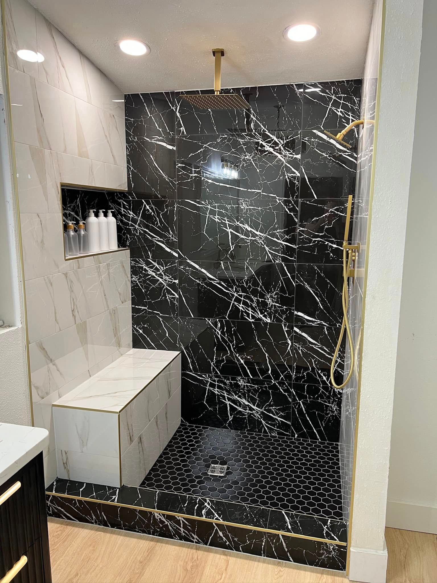 A bathroom with a walk in shower and a bench.