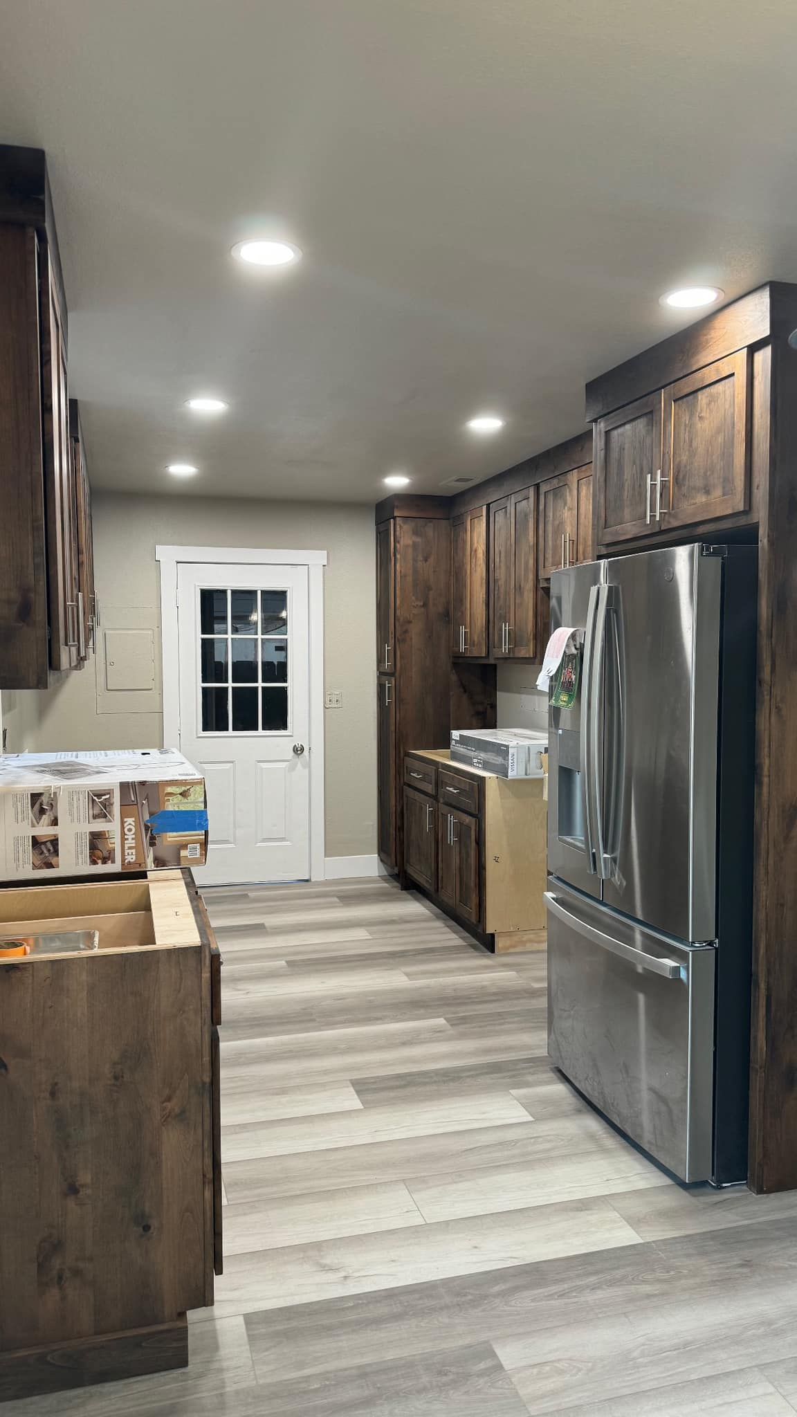 A kitchen with stainless steel appliances and wooden cabinets.