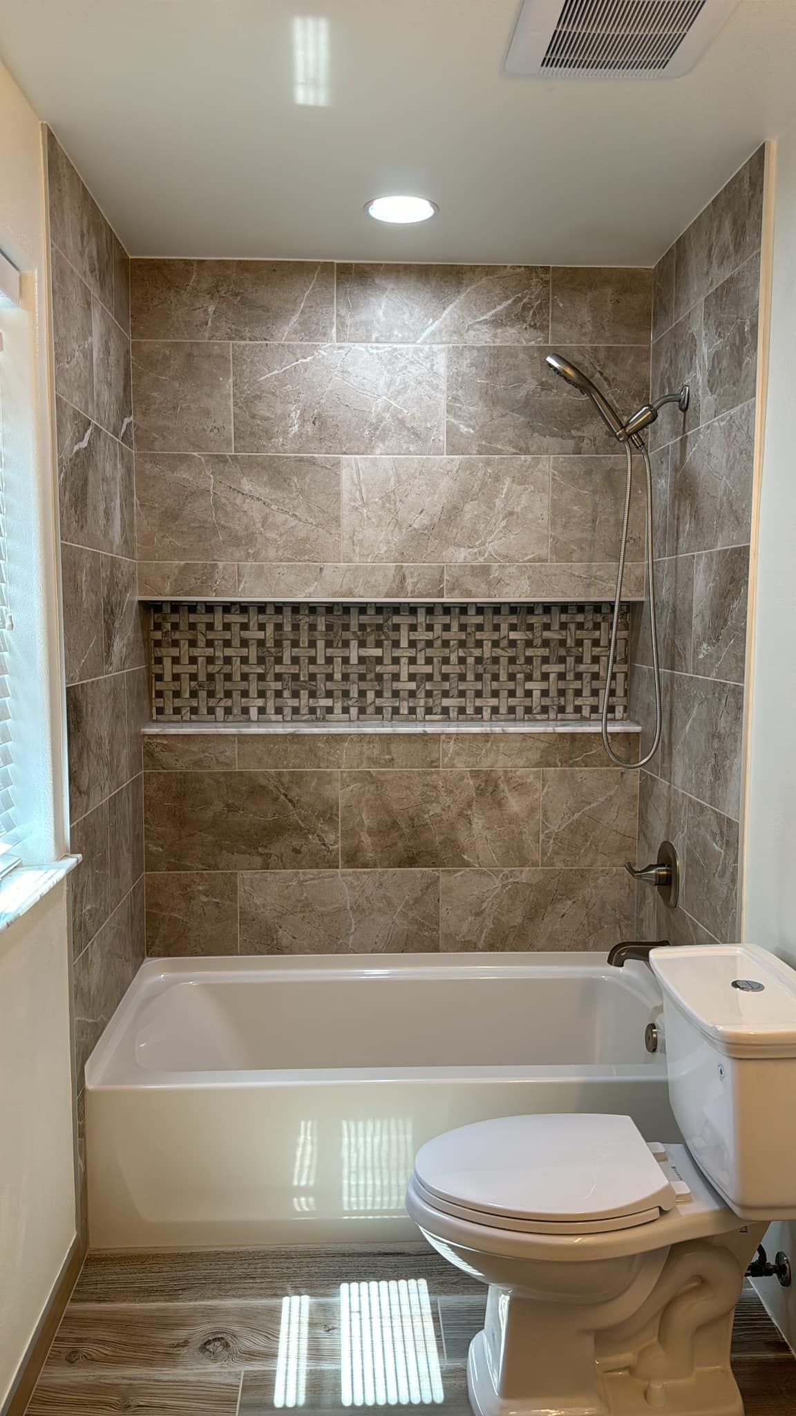 A bathroom with a tub , toilet , sink and shower.