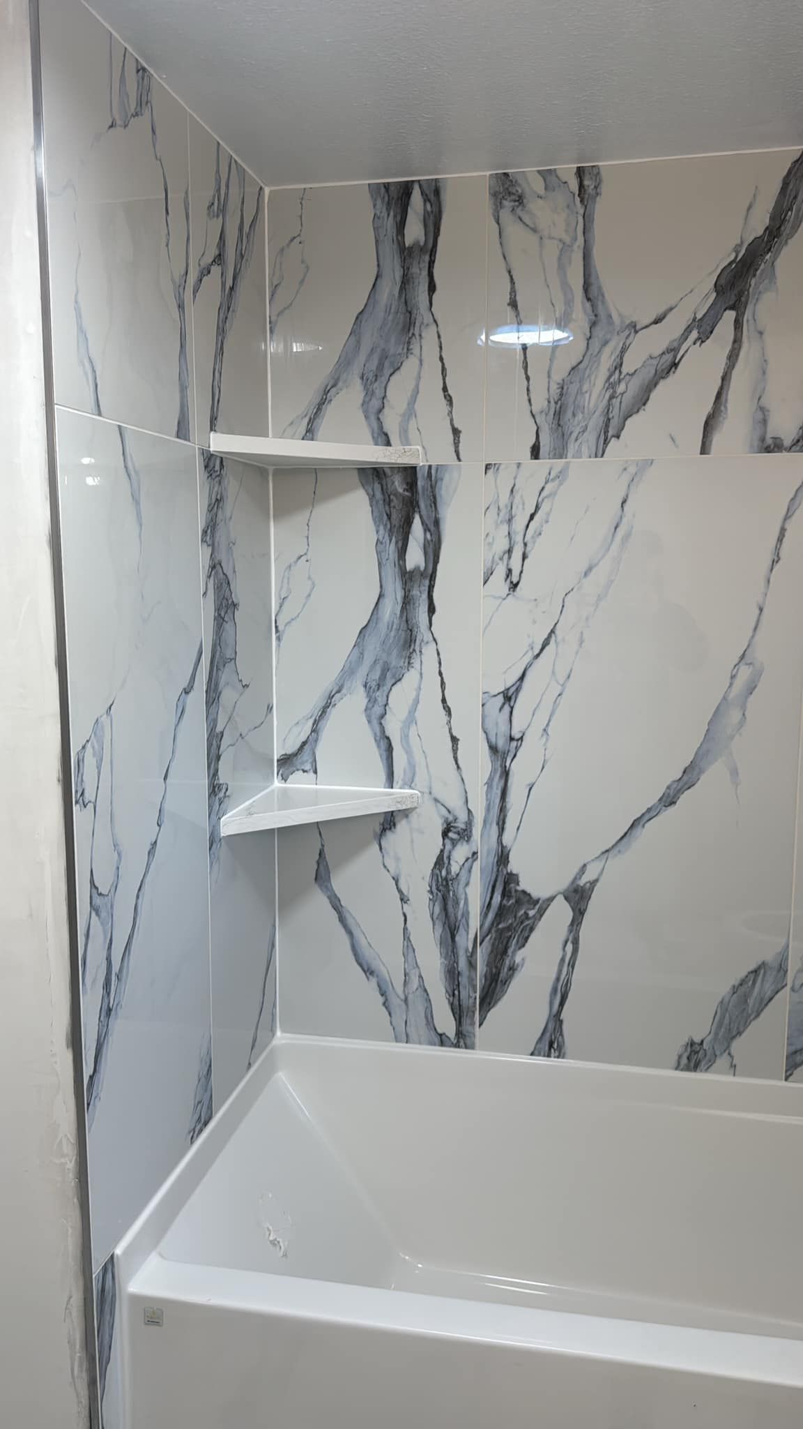 A bathroom with marble tiles and a bathtub.