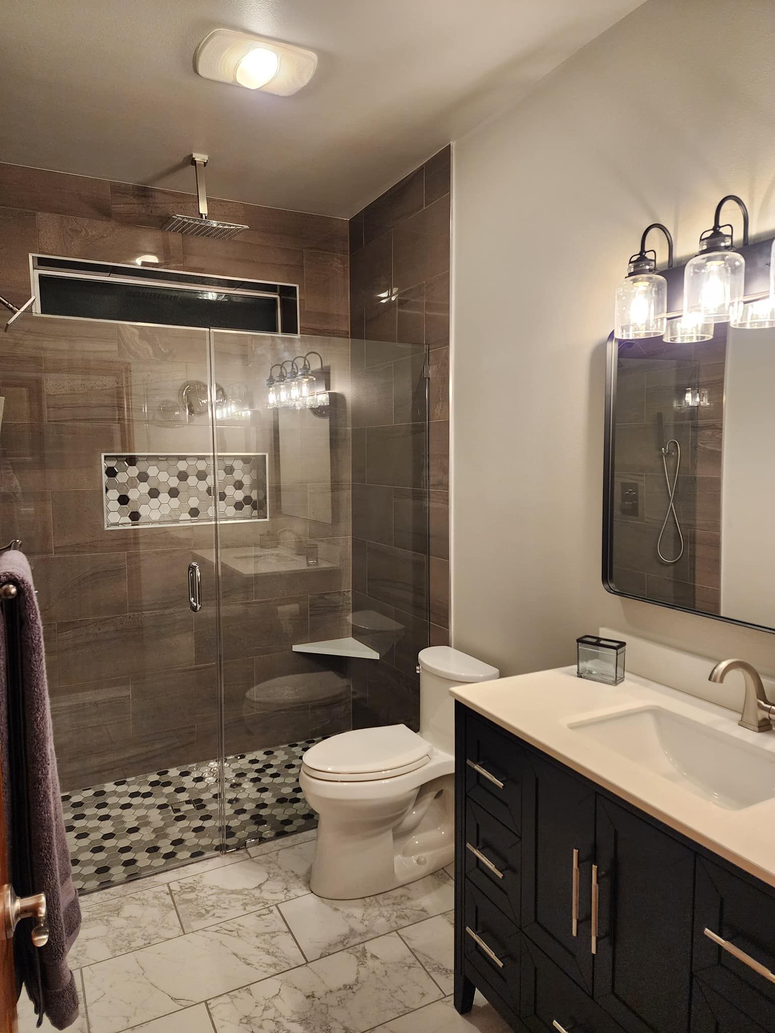 A bathroom with a toilet , sink , and walk in shower.