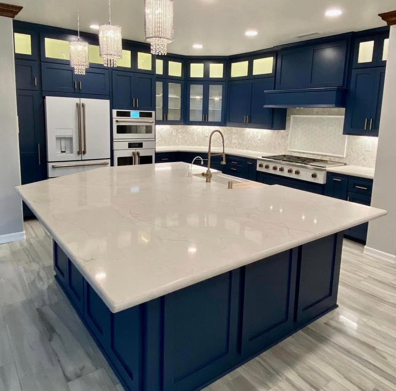 A kitchen with blue cabinets and a large island in the middle