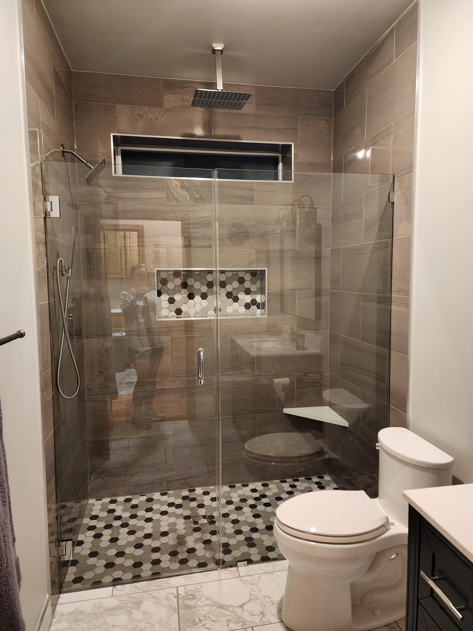 A bathroom with a walk in shower , toilet and sink.