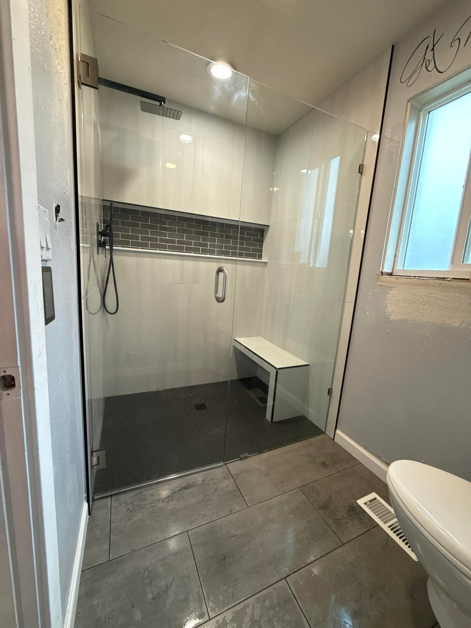 A bathroom with a walk in shower and a toilet.