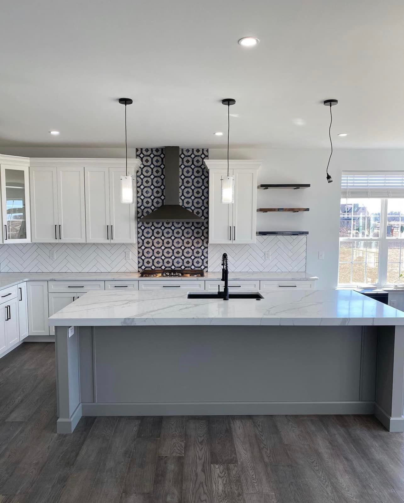 A kitchen with white cabinets and a large island in the middle.
