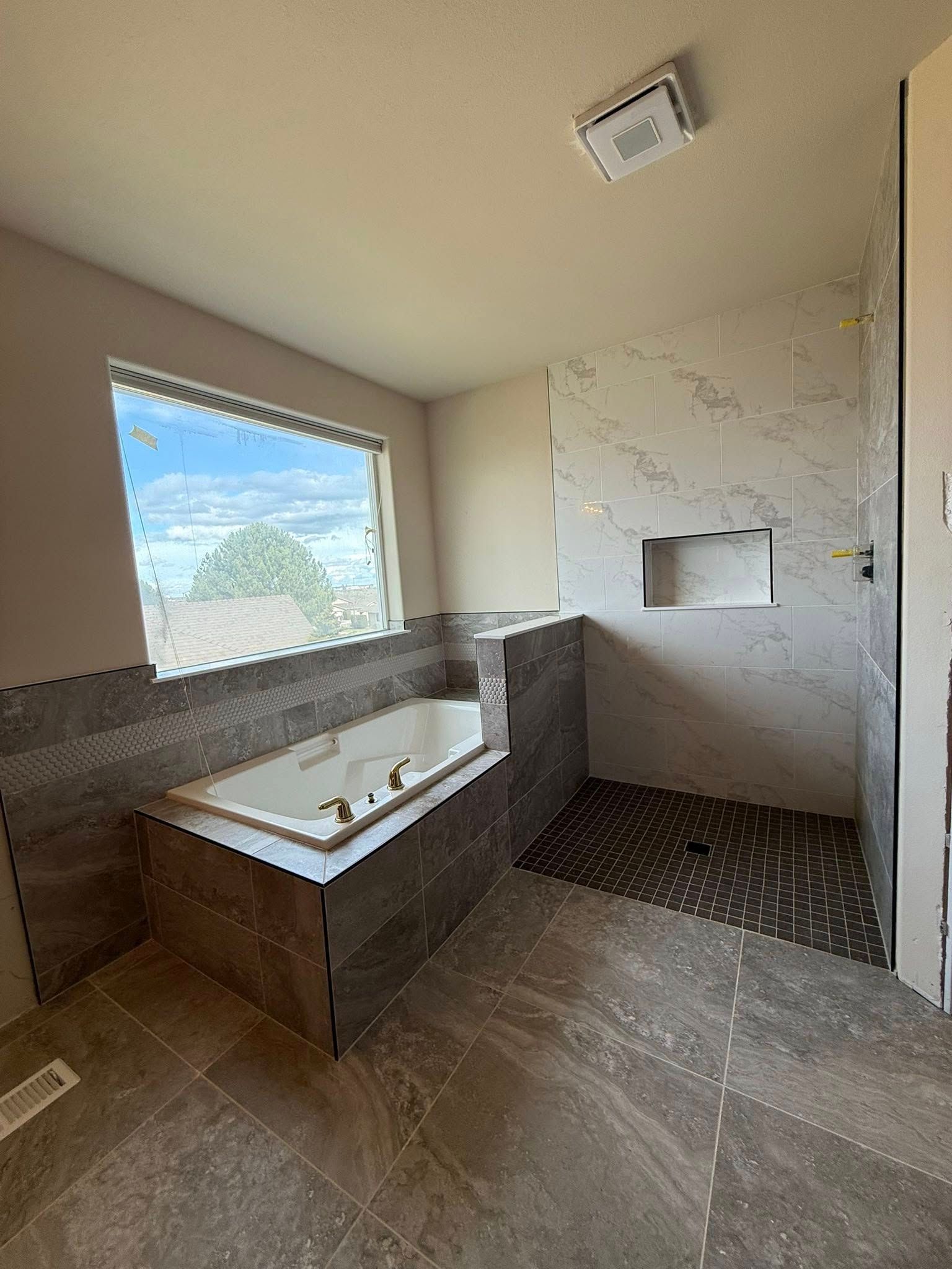 A bathroom with a jacuzzi tub and a walk in shower.