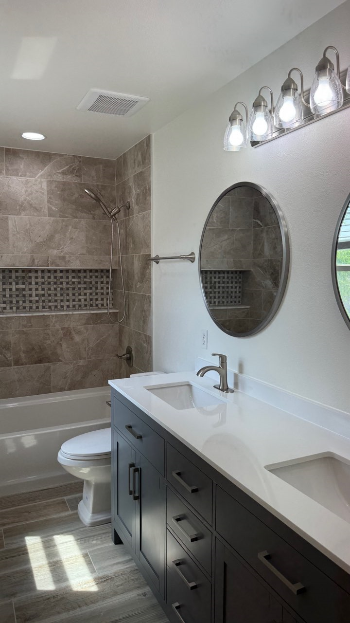 A bathroom with two sinks , a toilet , and a bathtub.