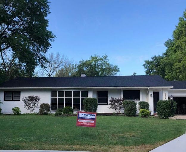 A house with a for sale sign in front of it