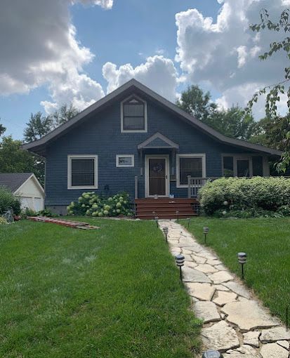 A blue house with a stone walkway leading to it