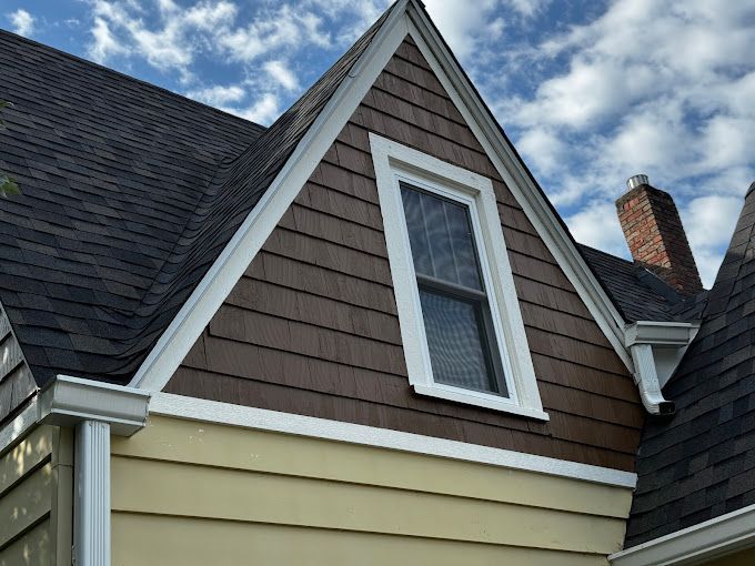 A house with a triangle shaped roof and a window