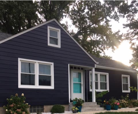 A blue house with white trim and a blue door