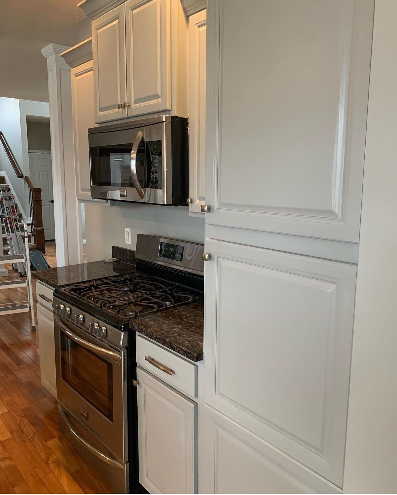 A kitchen with stainless steel appliances and white cabinets