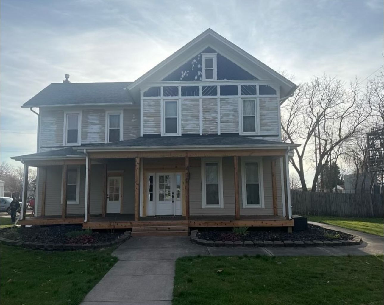 A large house with a porch and a walkway in front of it