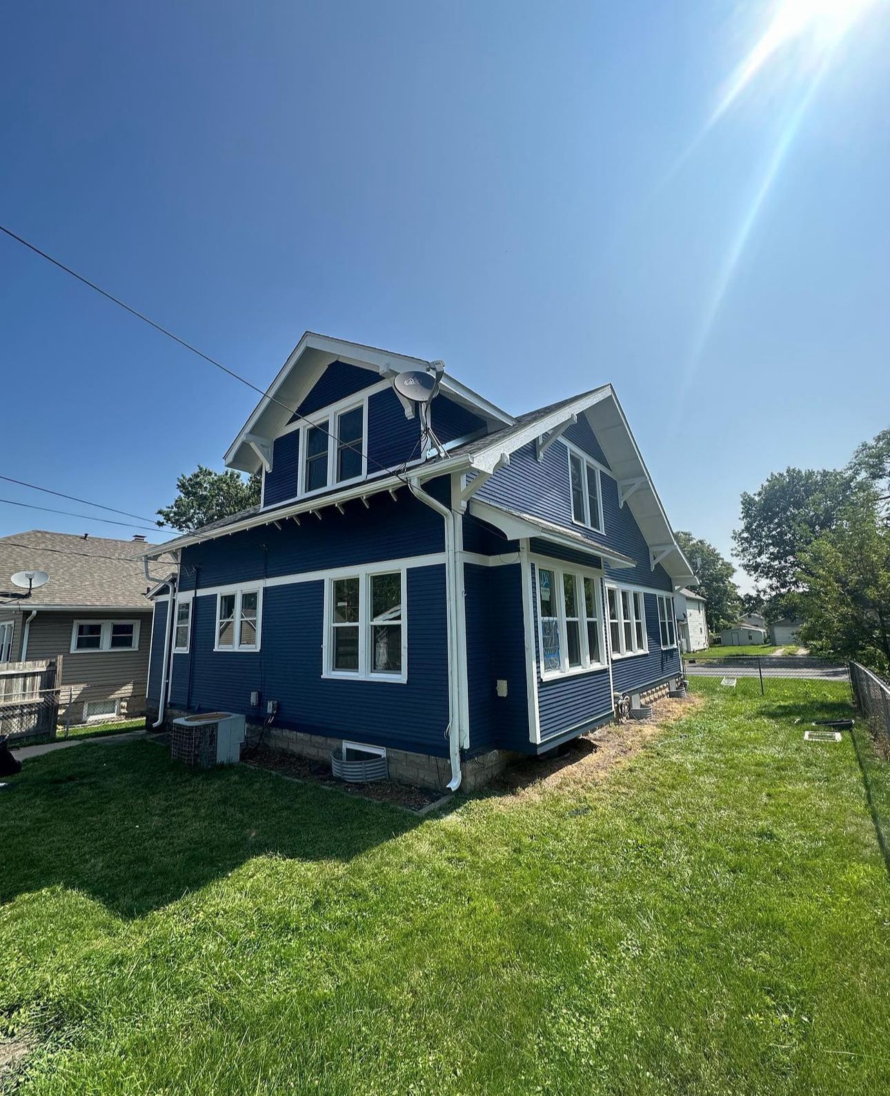 A screened in porch on the side of a house with stairs leading up to it.