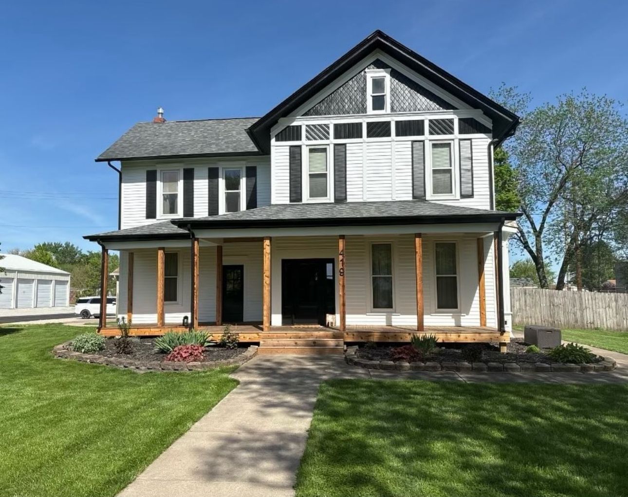 A large white house with a porch and a walkway in front of it.