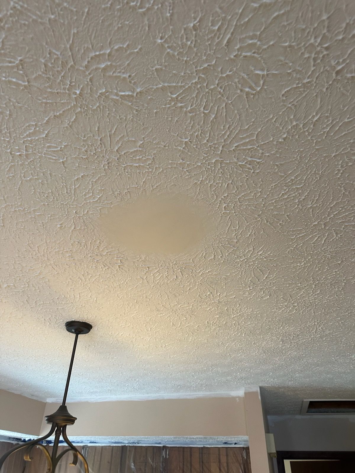 A white ceiling with a chandelier hanging from it in a living room.