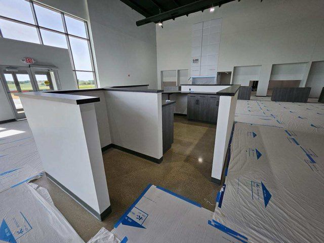 A room with a lot of white walls and a blue tarp on the floor