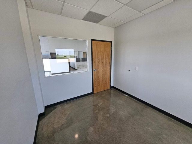 An empty room with a door and a window.