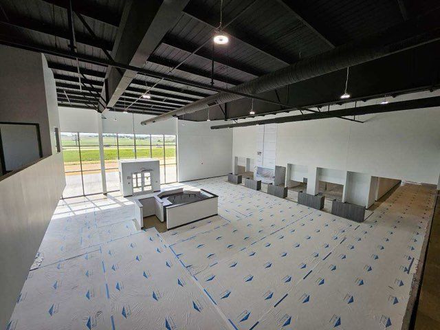 A large room with a lot of windows and a white floor.